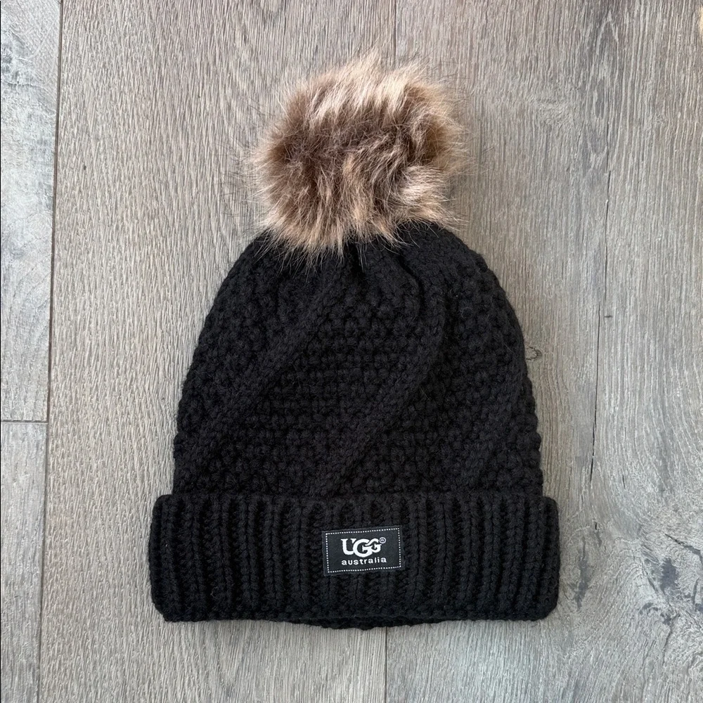 NWOT UGG Australia Black Cable Knit Fleece Lined Tan/Brown Faux Fur Pom Pom Hat - Picture 1 of 4